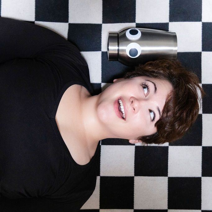 Sam Rager playfully looking at an urn with googly eyes